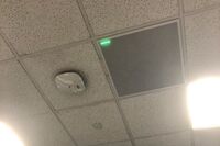 White 2¿ x 2¿ tile mounted in the ceiling to provide microphone coverage over student seating