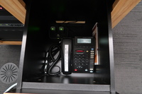 Pedestal - inside view of drawer showing two wireless mics in charging base and telephone