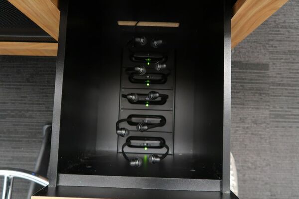 Pedestal - inside view of drawer showing assistive listening devices in charging base