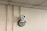 Camera mounted to a wall and instructor enabled adjustments to the lens to allow the instructor to be "seen" by the camera in more locations around the room