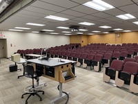 Back of room view of student auditorium seating and exit door at front left