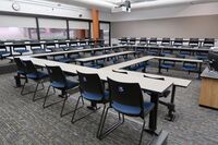 Back of room view of student tiered fixed table and chair seating 