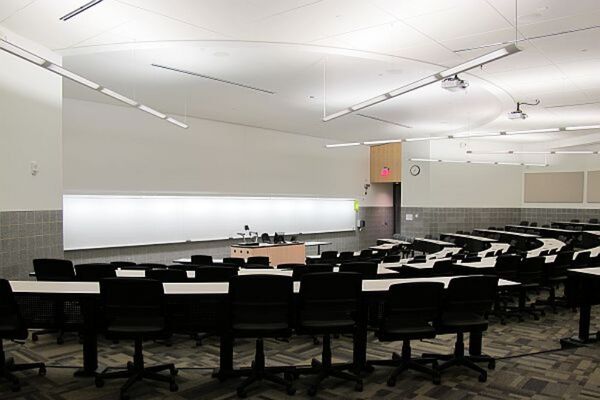 Front of room view with lectern center in front of markerboard and exit door on the right