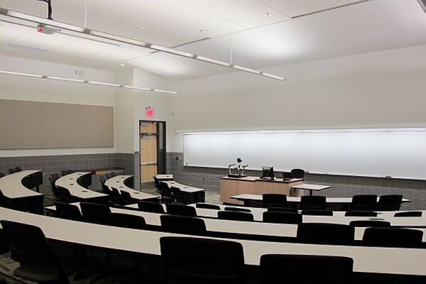 Front of room view with lectern center in front of markerboard and exit door on the left