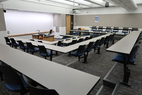 Front of room view with lectern center in front of markerboard and exit door to the front right
