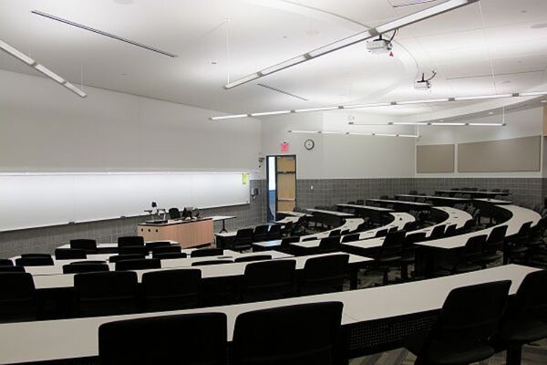 Front of room view with lectern center in front of markerboard and with exit door front right