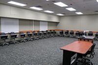 Back of room view of student tablet arm seating and markerboards on side and back walls