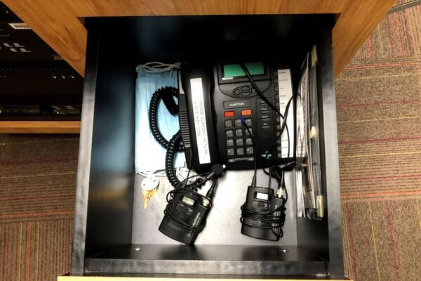 Pedestal - inside view of drawer showing two wireless mics and telephone