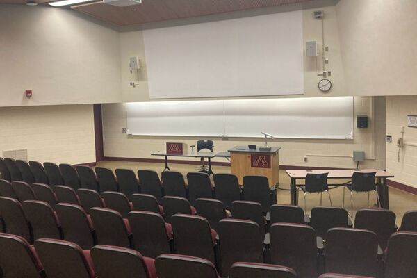 Front of room view with lectern on right in front of markerboard and projection area above