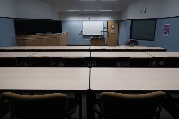 Front of room view with lectern center in front of markerboard and display panels on the left